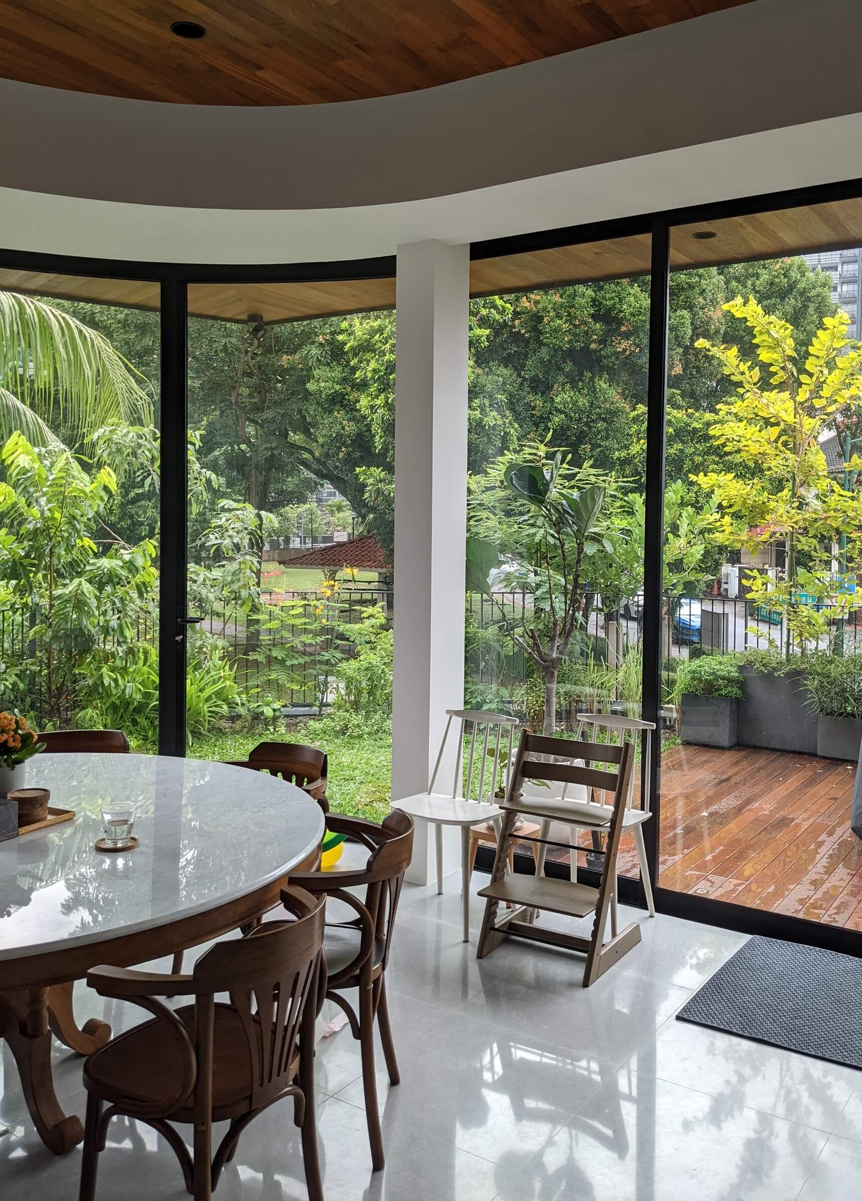 Curved glass frames borrowed views of the distant park, with a deck for outdoor dining.